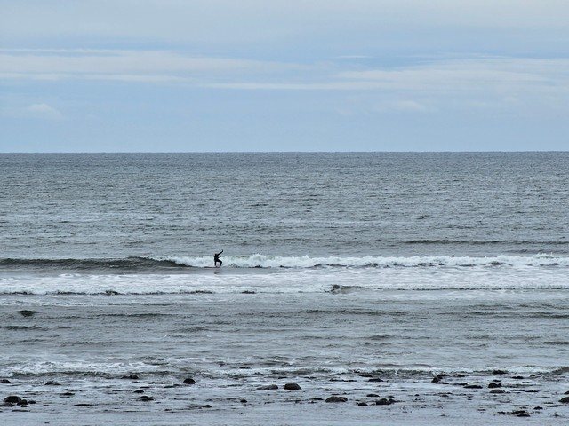 Surfer wobbling on a wave in front of the shop